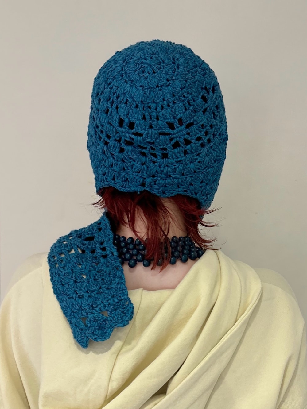 イエロー系のパーカー、ブルー系のボディバッグ/ウエストポーチ、ブルー系のスカートを着用したレディースの冬コーディネートの2枚目の写真