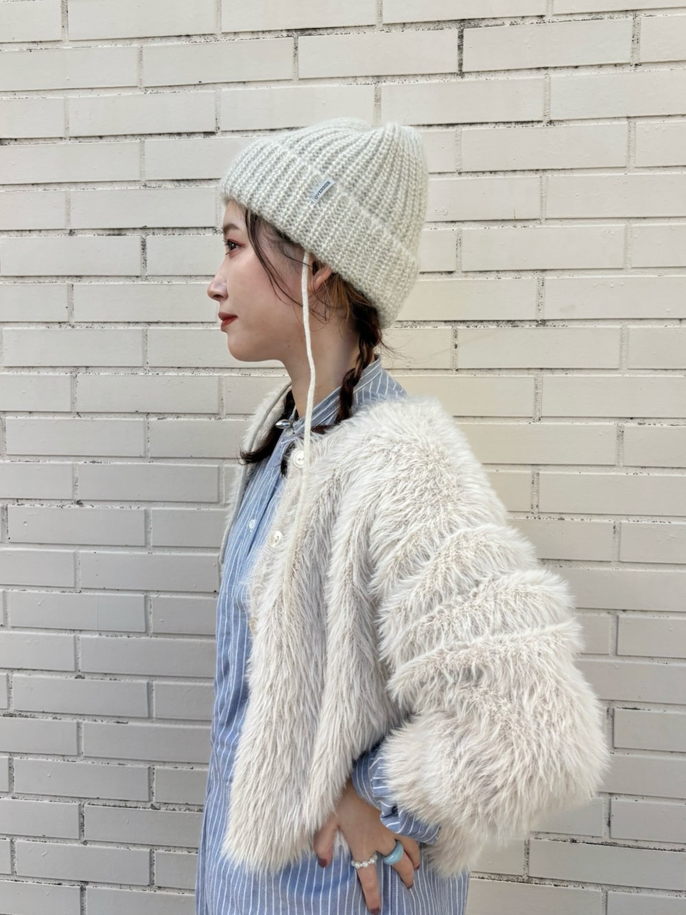 ホワイト系のカーディガン/ボレロ、ブルー系のシャツ/ブラウス、ブルー系のデニムパンツを着用したレディースの冬コーディネートの2枚目の写真