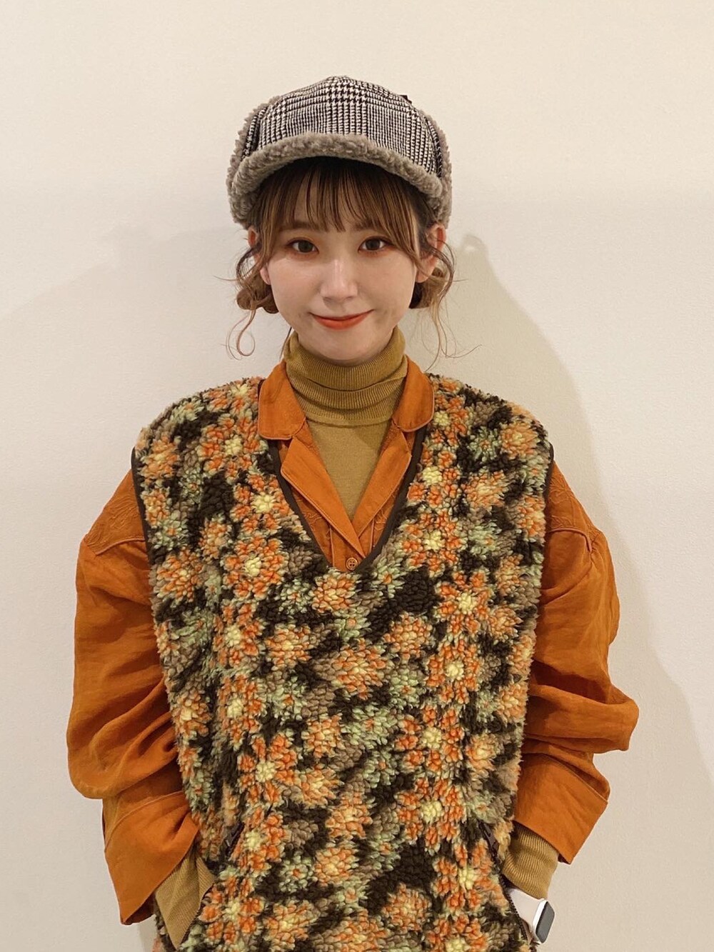 ベージュ系のベスト、ブラウン系のパンツ、オレンジ系のシューズを着用したレディースの秋コーディネートの2枚目の写真