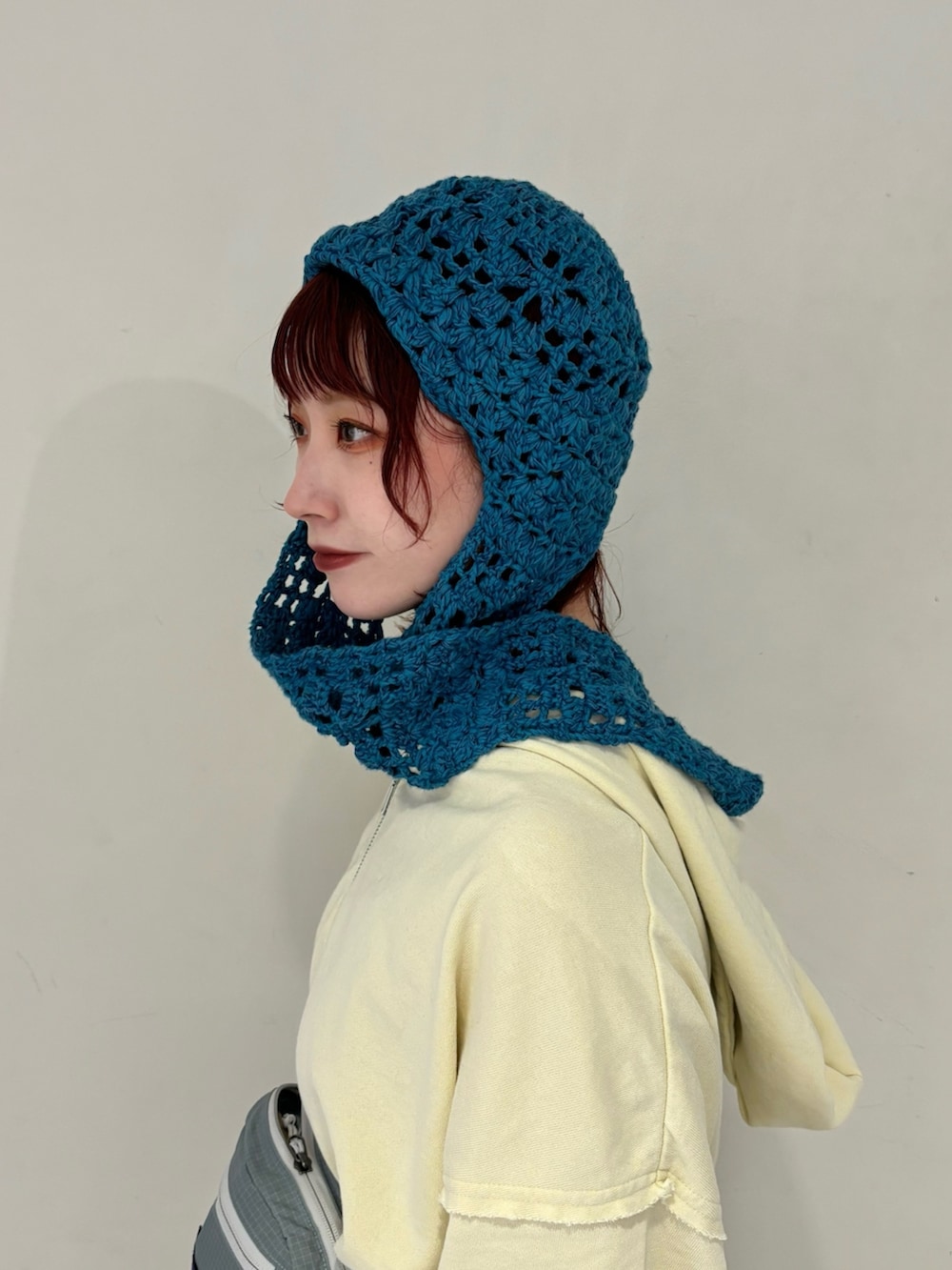 イエロー系のパーカー、ブルー系のボディバッグ/ウエストポーチ、ブルー系のスカートを着用したレディースの冬コーディネートの3枚目の写真