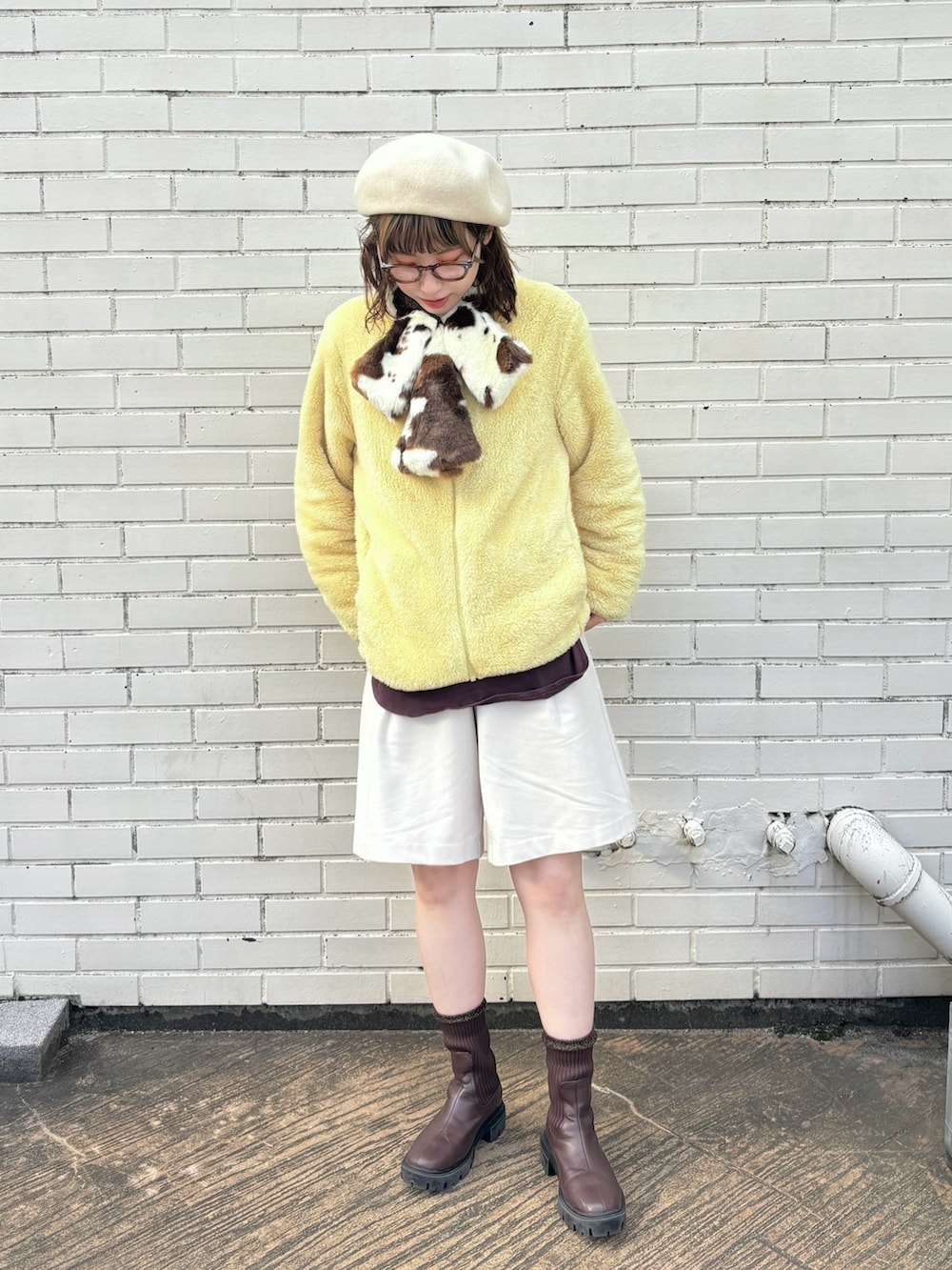 イエロー系のジャケット/アウター、ホワイト系のパンツ、ブラウン系のブーツを着用したレディースの冬コーディネートの3枚目の写真