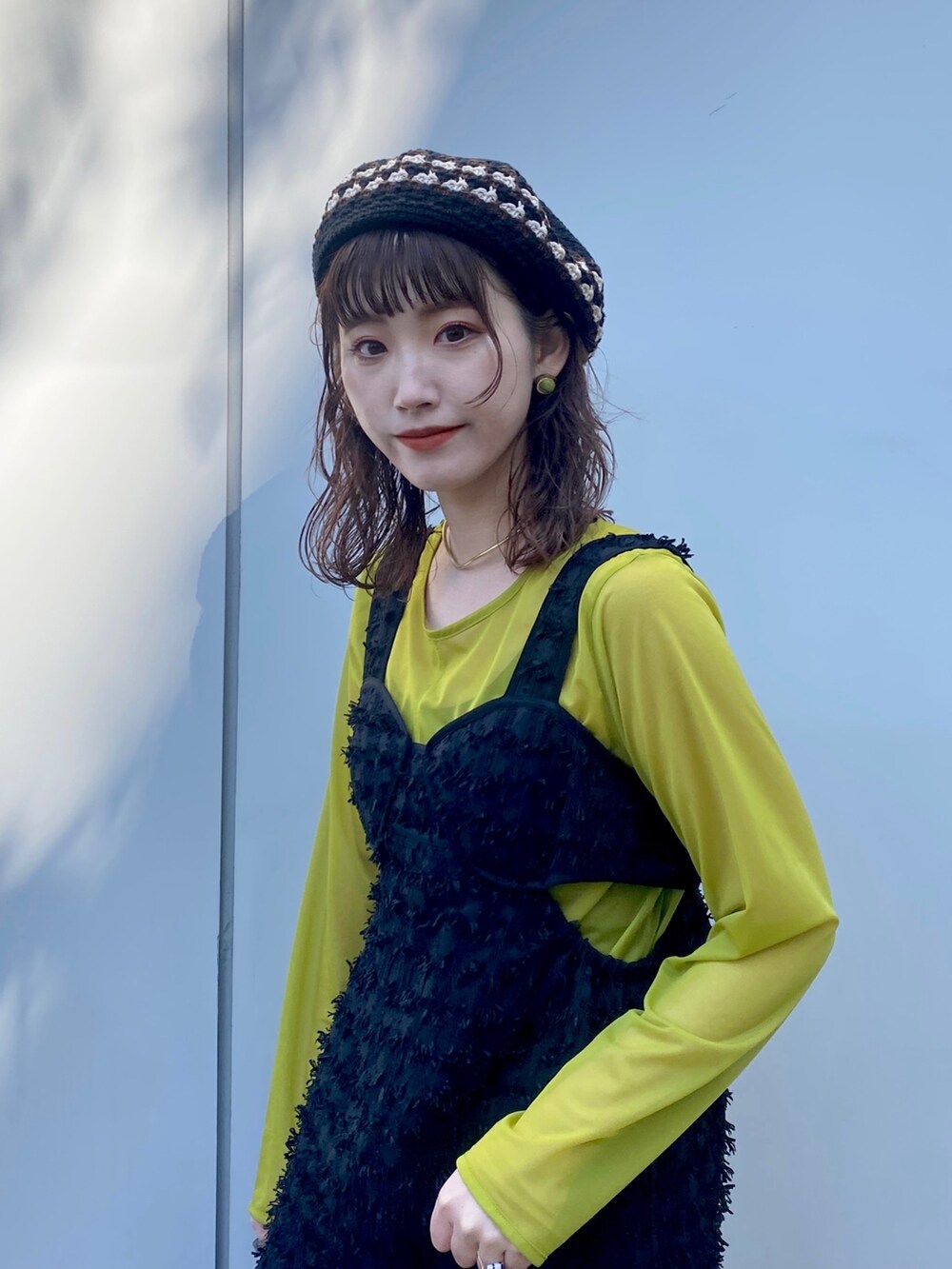 ブラック系のワンピース、グリーン系のTシャツ/カットソー、ブラック系のハンチング/ベレー帽を着用したレディースの冬コーディネートの2枚目の写真