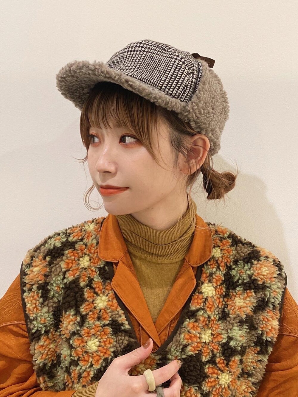 ベージュ系のベスト、ブラウン系のパンツ、オレンジ系のシューズを着用したレディースの秋コーディネートの3枚目の写真