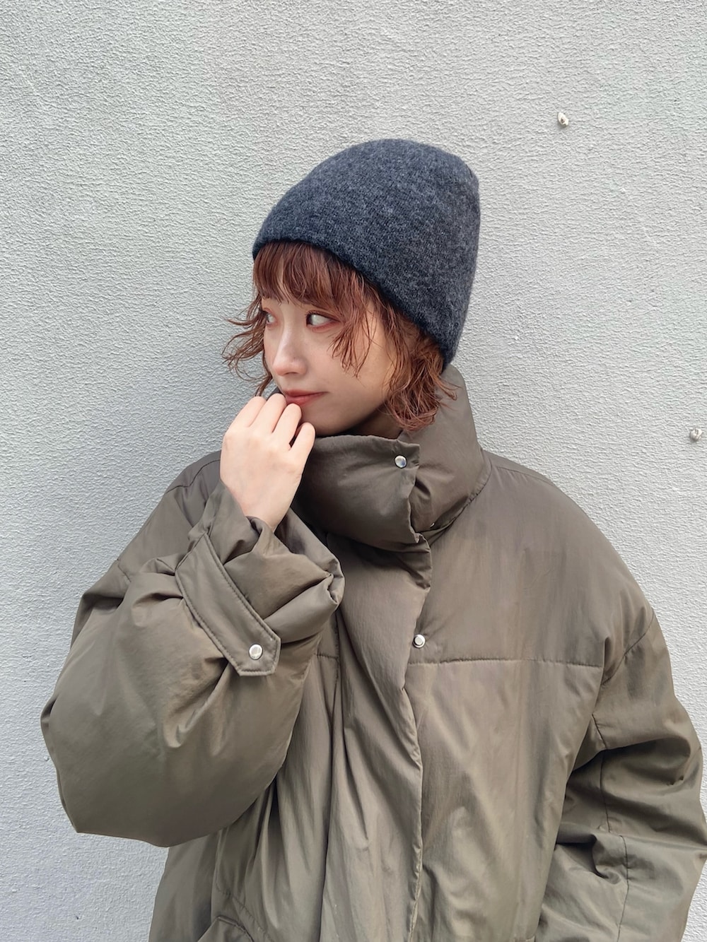 グリーン系のダウンジャケット/コート、グレー系のパンツ、ブラウン系のモカシン/デッキシューズを着用したレディースの冬コーディネートの8枚目の写真