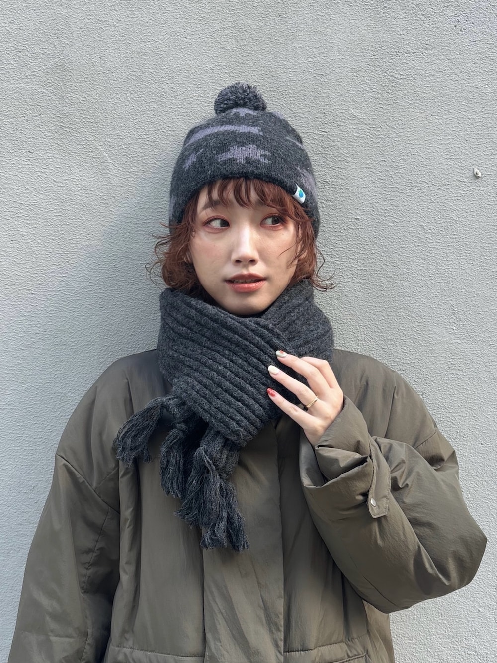 グリーン系のダウンジャケット/コート、グレー系のパンツ、ブラウン系のモカシン/デッキシューズを着用したレディースの冬コーディネートの2枚目の写真