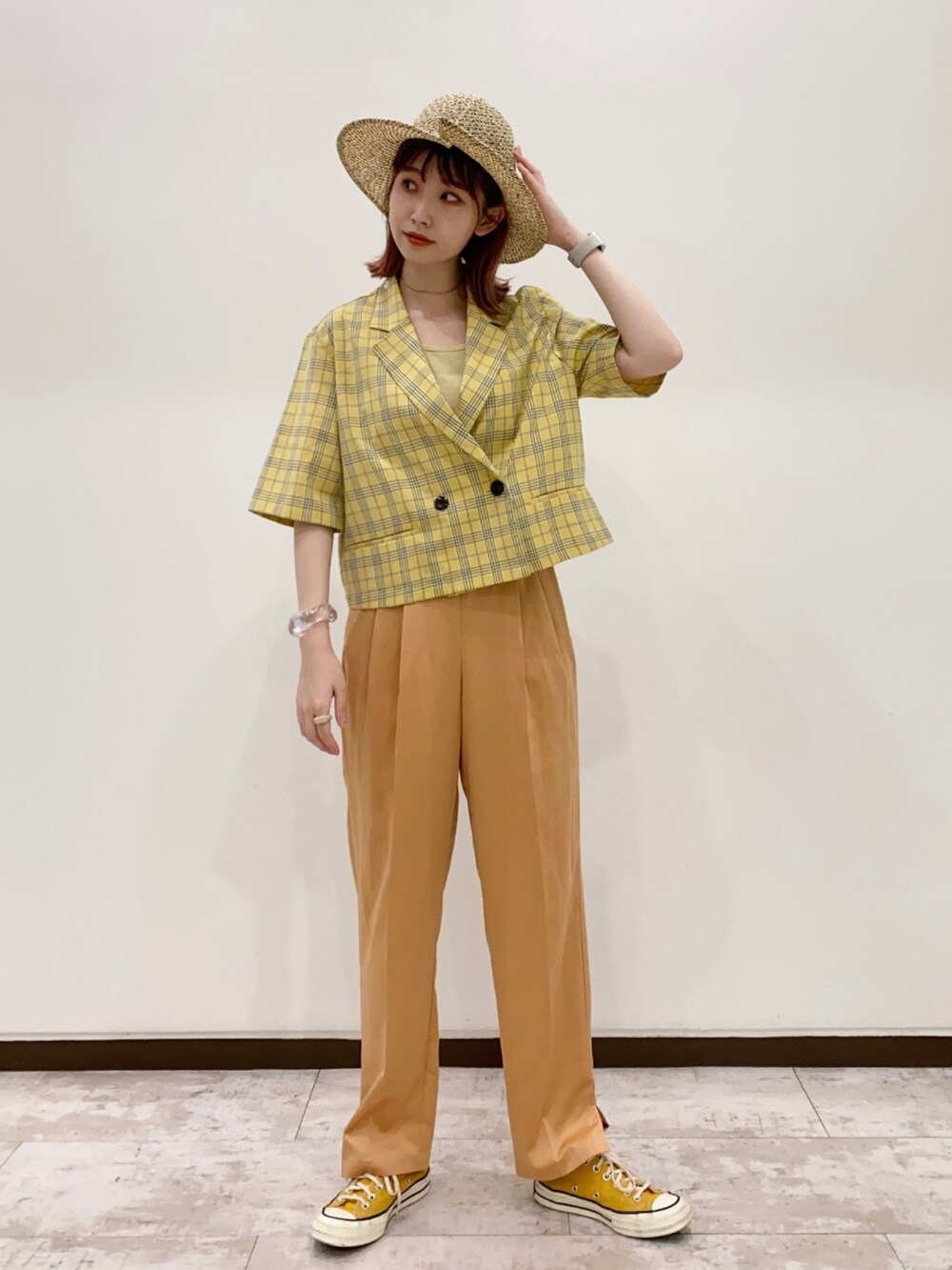 イエロー系のトップス、オレンジ系のパンツ、イエロー系のスニーカーを着用したレディースの夏コーディネートの2枚目の写真