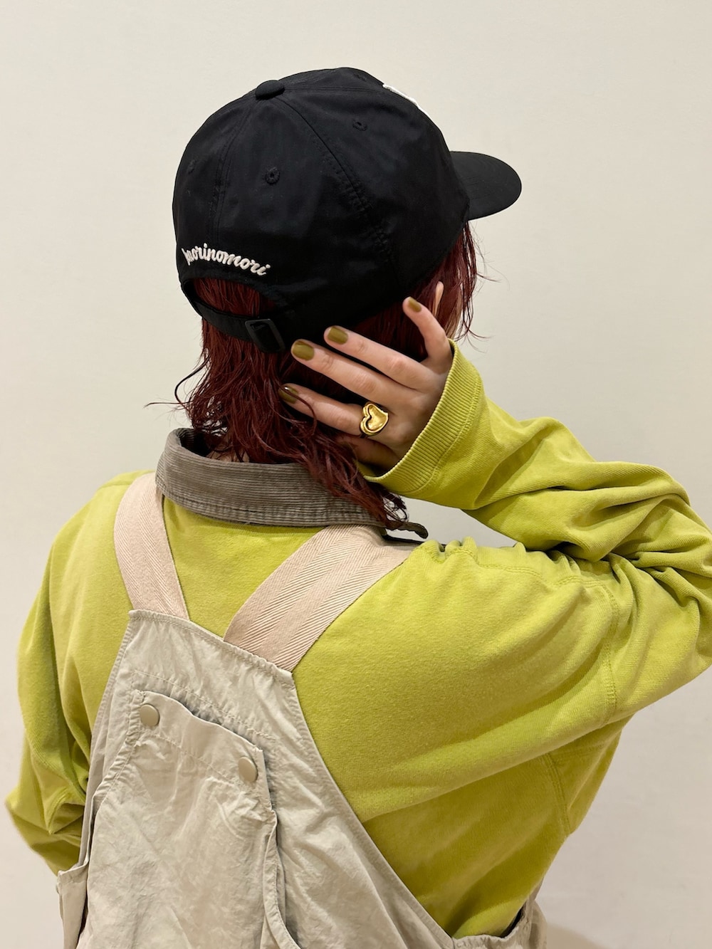 グリーン系のトップス、ベージュ系のベスト、ブラック系のデニムパンツを着用したレディースの冬コーディネートの3枚目の写真