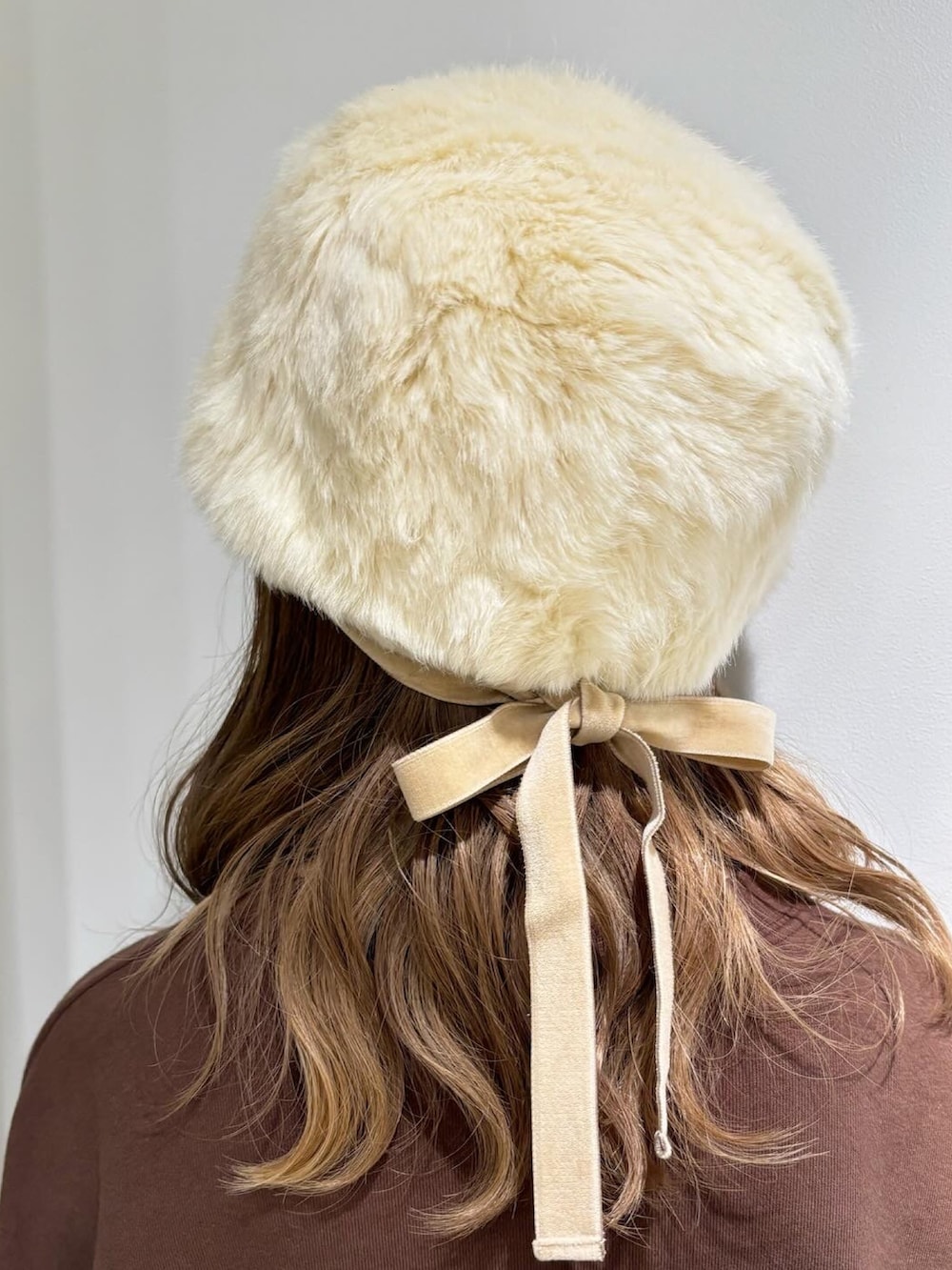 ベージュ系のベスト、イエロー系のTシャツ/カットソー、ブラウン系のデニムスカートを着用したレディースの秋コーディネートの4枚目の写真