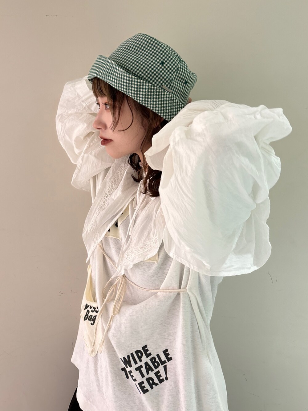 ホワイト系のシャツ/ブラウス、ホワイト系のTシャツ/カットソー、ブラウン系のパンツを着用したレディースの春コーディネートの2枚目の写真