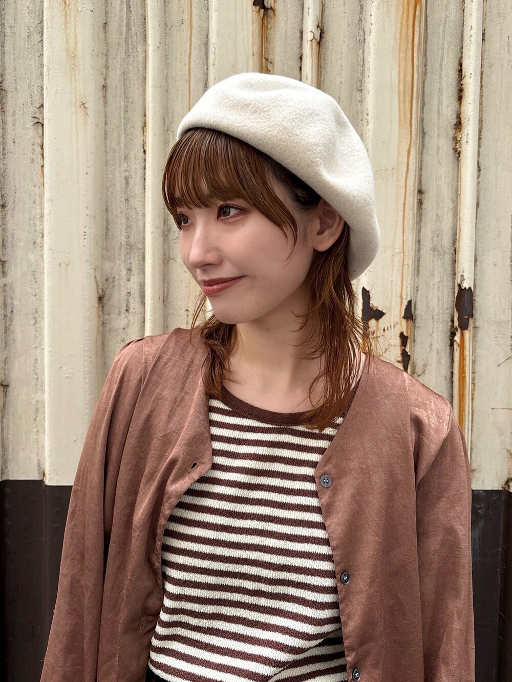 イエロー系のスニーカー、ホワイト系のハンチング/ベレー帽を着用したレディースの秋コーディネートの2枚目の写真