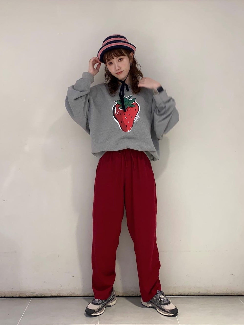 グレー系のスウェット、ピンク系のパンツ、グレー系のスニーカーを着用したレディースの夏コーディネートの2枚目の写真