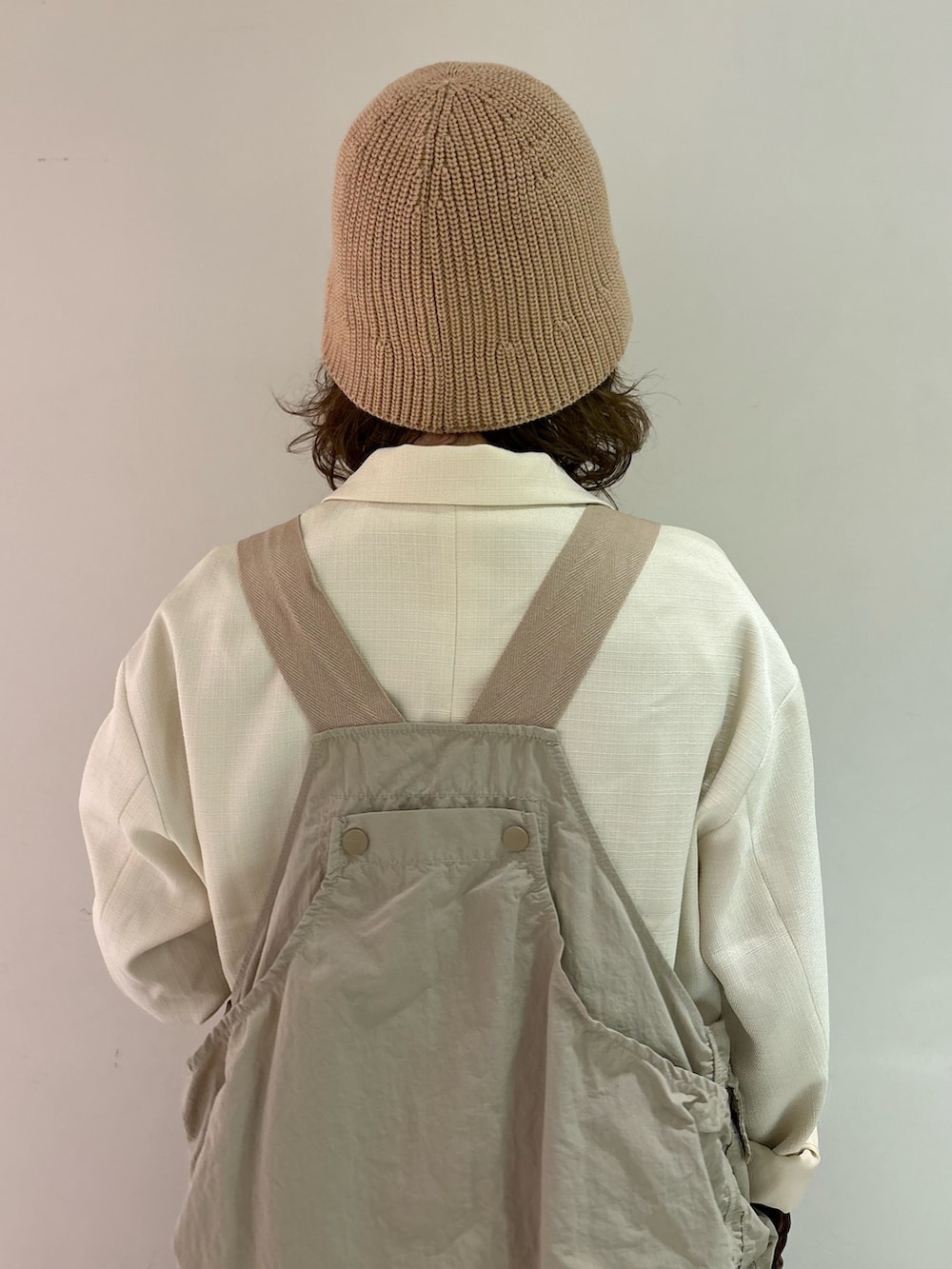 ブラウン系のTシャツ/カットソー、ベージュ系のベスト、ホワイト系のテーラードジャケットを着用したレディースの春コーディネートの4枚目の写真