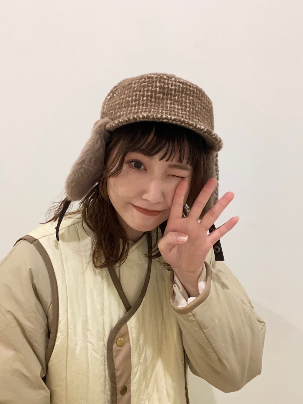 ホワイト系のその他アウター、ブラウン系のブーツ、ブラウン系のキャップを着用したレディースの冬コーディネートの2枚目の写真