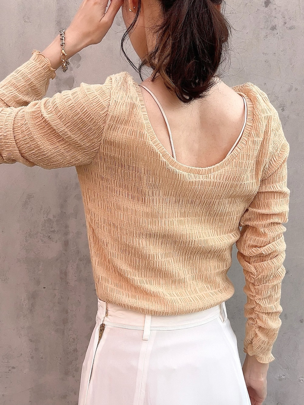 オレンジ系のTシャツ/カットソー、ホワイト系のスカート、ブラック系のシューズを着用したレディースの春コーディネートの5枚目の写真