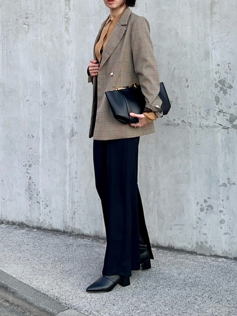 ブラウン系のニット/セーター、ベージュ系のテーラードジャケット、ブラック系のスカートを着用したレディースの冬コーディネートの2枚目の写真