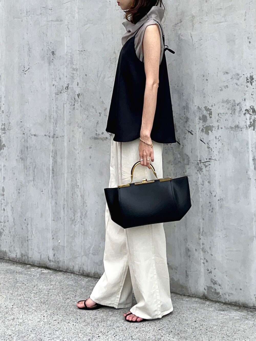 グレー系のTシャツ/カットソー、ブラック系のキャミソール、ホワイト系のパンツを着用したレディースの夏コーディネートの3枚目の写真