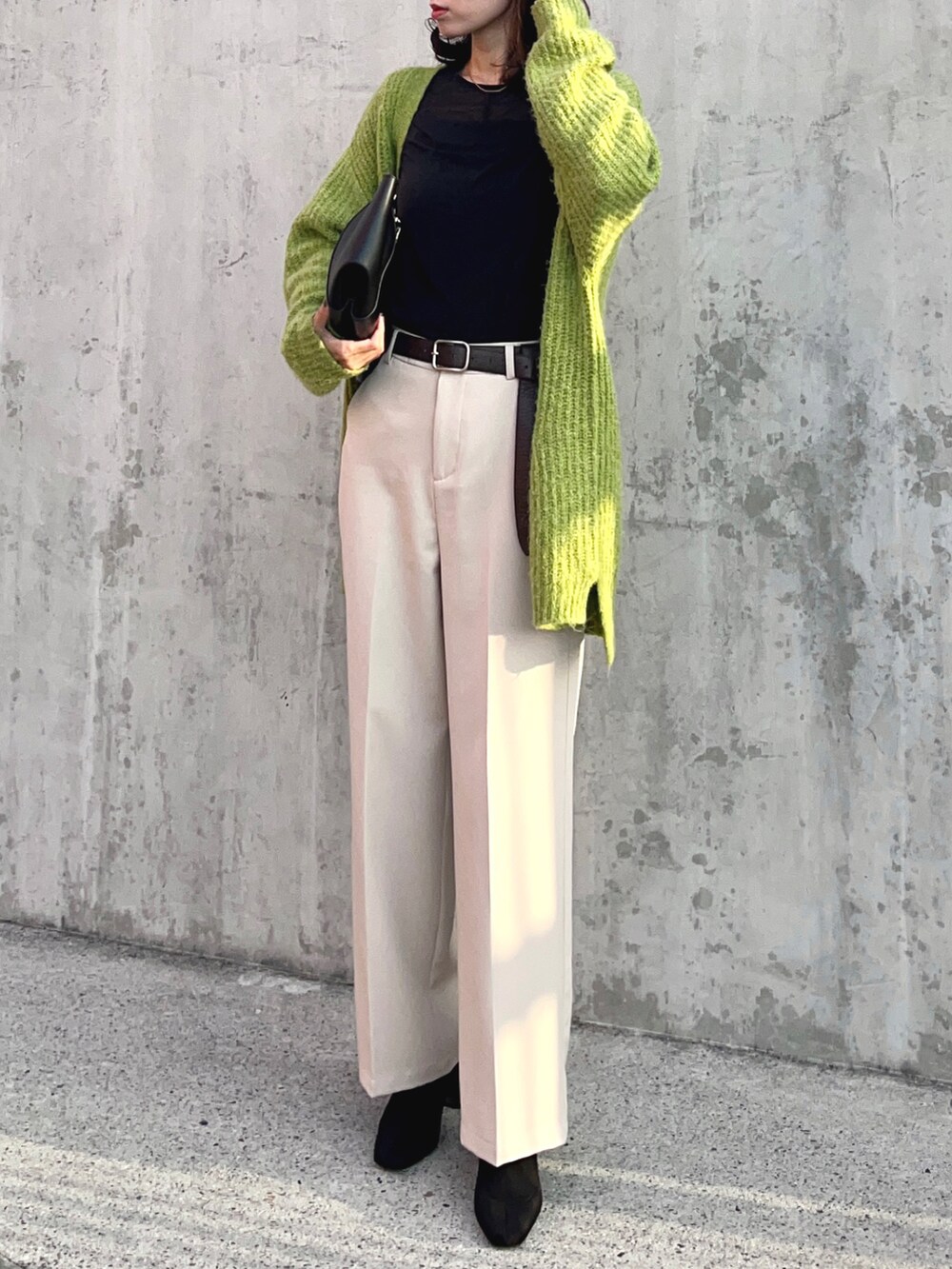 ブラック系のTシャツ/カットソー、グリーン系のカーディガン/ボレロ、ホワイト系のスラックスを着用したレディースの秋コーディネートの2枚目の写真