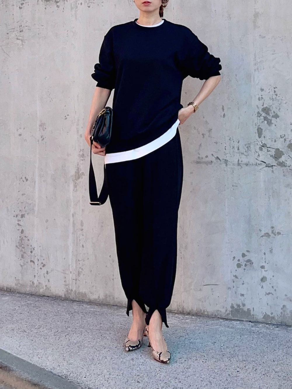 ブラック系のスウェット、ホワイト系のTシャツ/カットソー、ブラック系のその他パンツを着用したレディースの春コーディネートの3枚目の写真