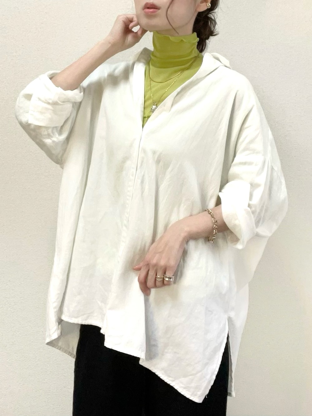 グリーン系のTシャツ/カットソー、ホワイト系のシャツ/ブラウス、ブラック系のスカートを着用したレディースの春コーディネートの2枚目の写真