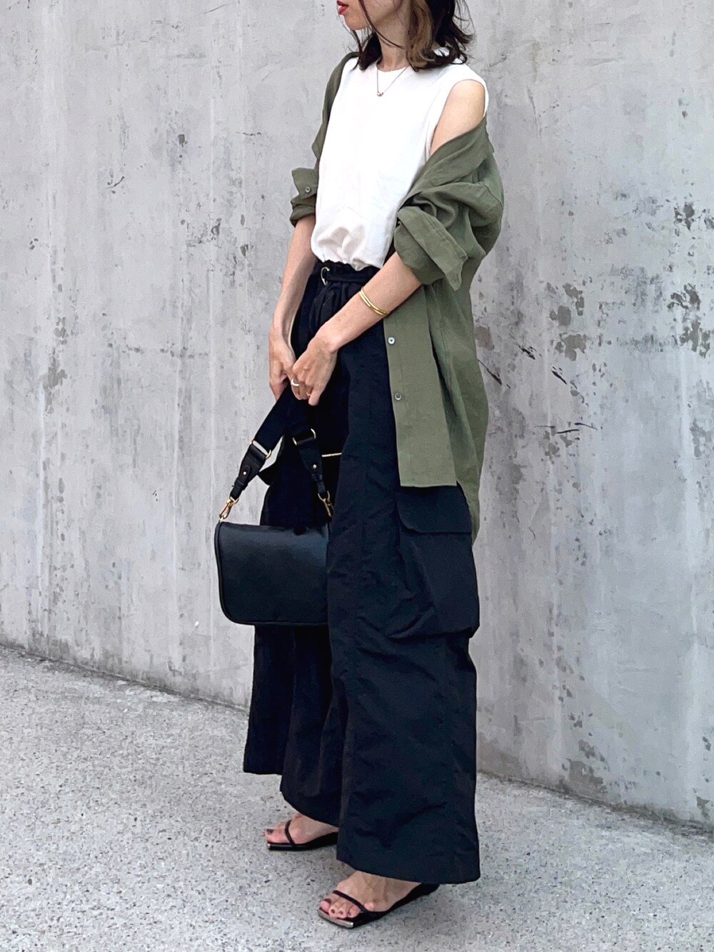 ホワイト系のTシャツ/カットソー、ブラック系のスカート、ブラック系のサンダルを着用したレディースの夏コーディネートの3枚目の写真