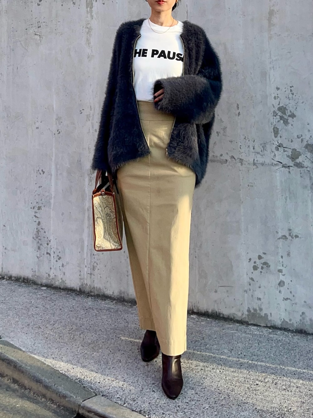 グレー系のカーディガン/ボレロ、ホワイト系のTシャツ/カットソー、ベージュ系のスカートを着用したレディースの秋コーディネートの2枚目の写真