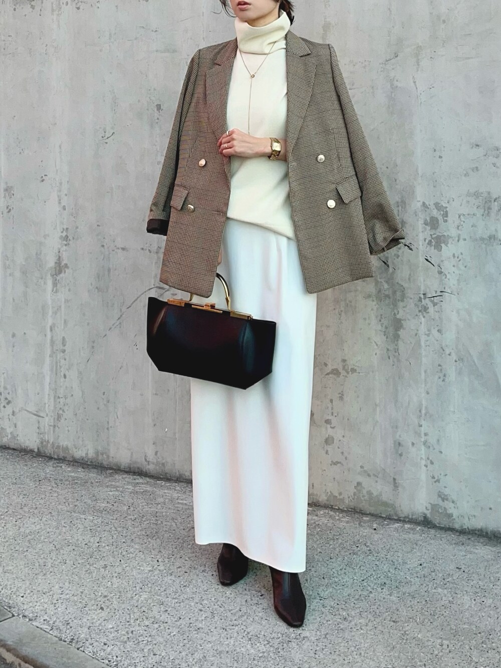 ホワイト系のニット/セーター、ベージュ系のテーラードジャケット、ホワイト系のスカートを着用したレディースの冬コーディネートの2枚目の写真