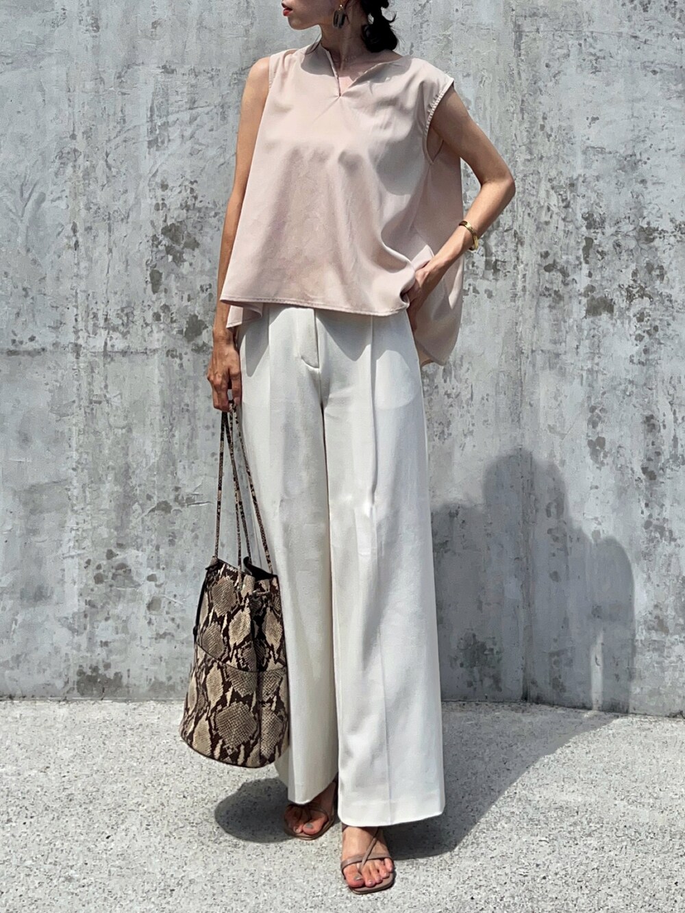 ホワイト系のシャツ/ブラウス、ホワイト系のパンツ、ベージュ系のサンダルを着用したレディースの夏コーディネートの2枚目の写真