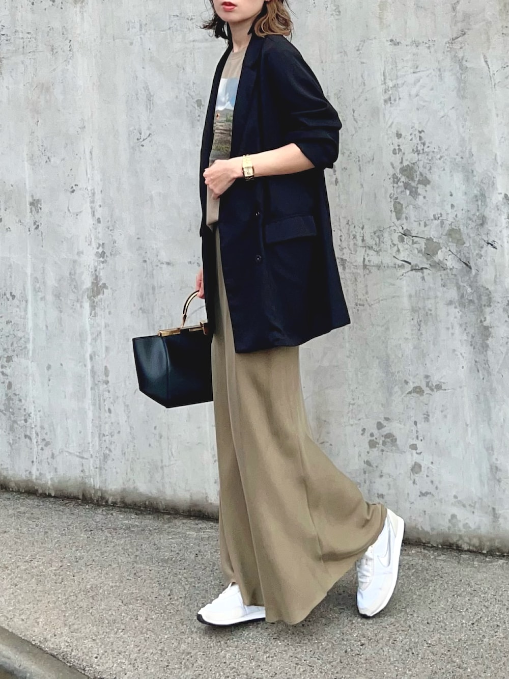 ベージュ系のTシャツ/カットソー、グリーン系のスカート、シルバー系のスニーカーを着用したレディースの冬コーディネートの2枚目の写真