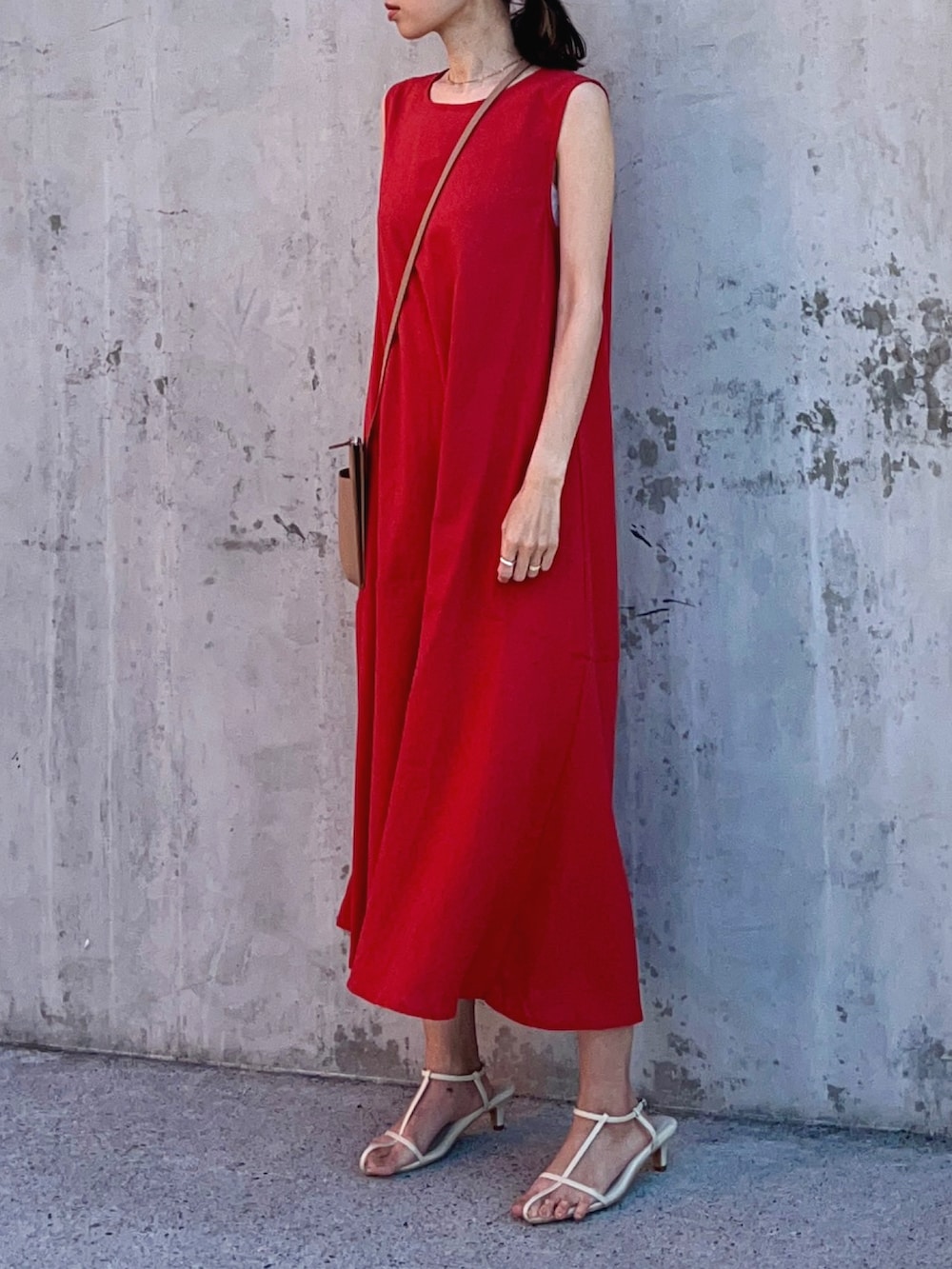 レッド系のワンピース、ホワイト系のサンダル、ベージュ系のバッグを着用したレディースの春コーディネートの2枚目の写真