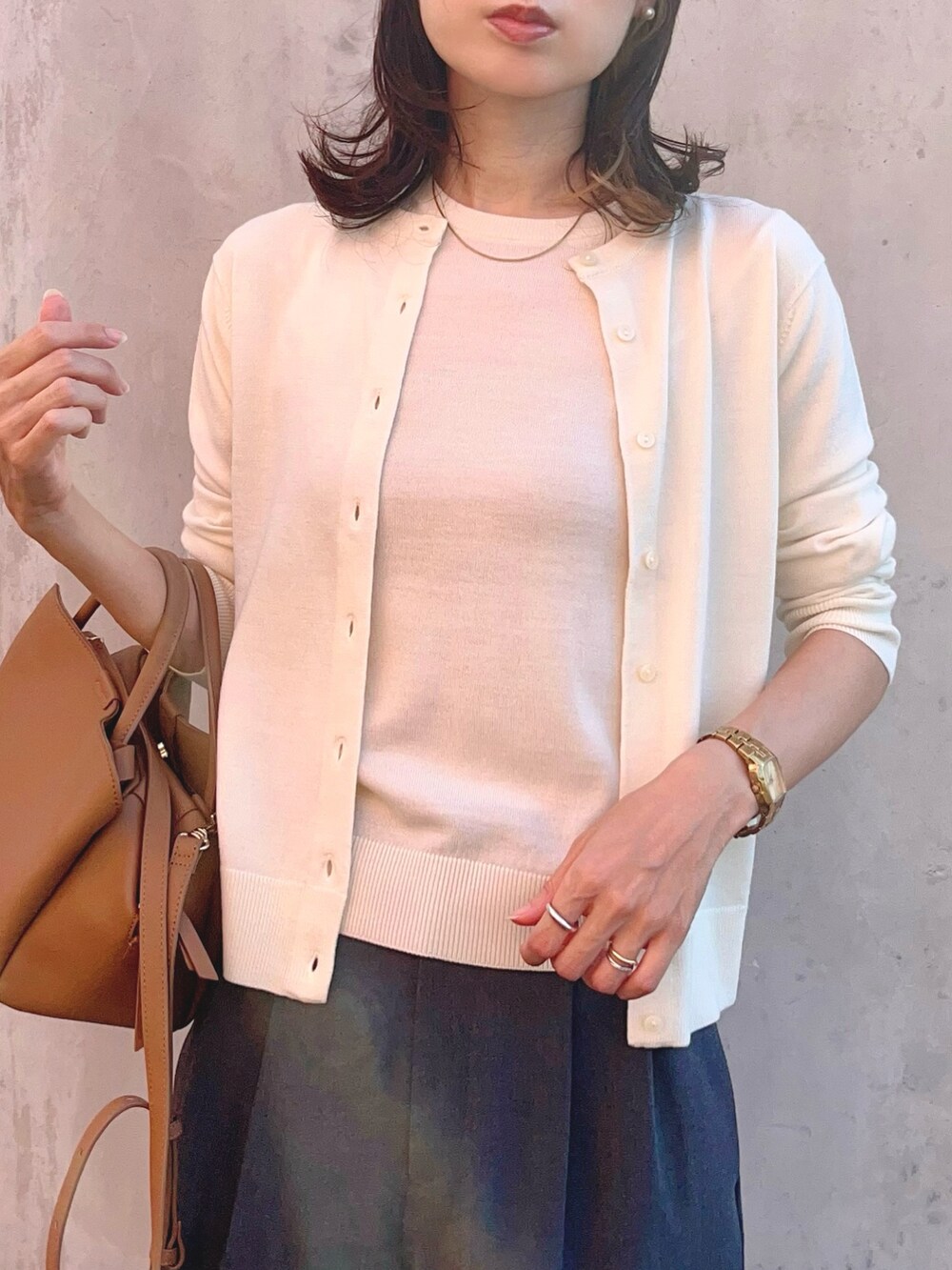 ホワイト系のニット/セーター、ホワイト系のカーディガン/ボレロ、グレー系のパンツを着用したレディースの秋コーディネートの4枚目の写真