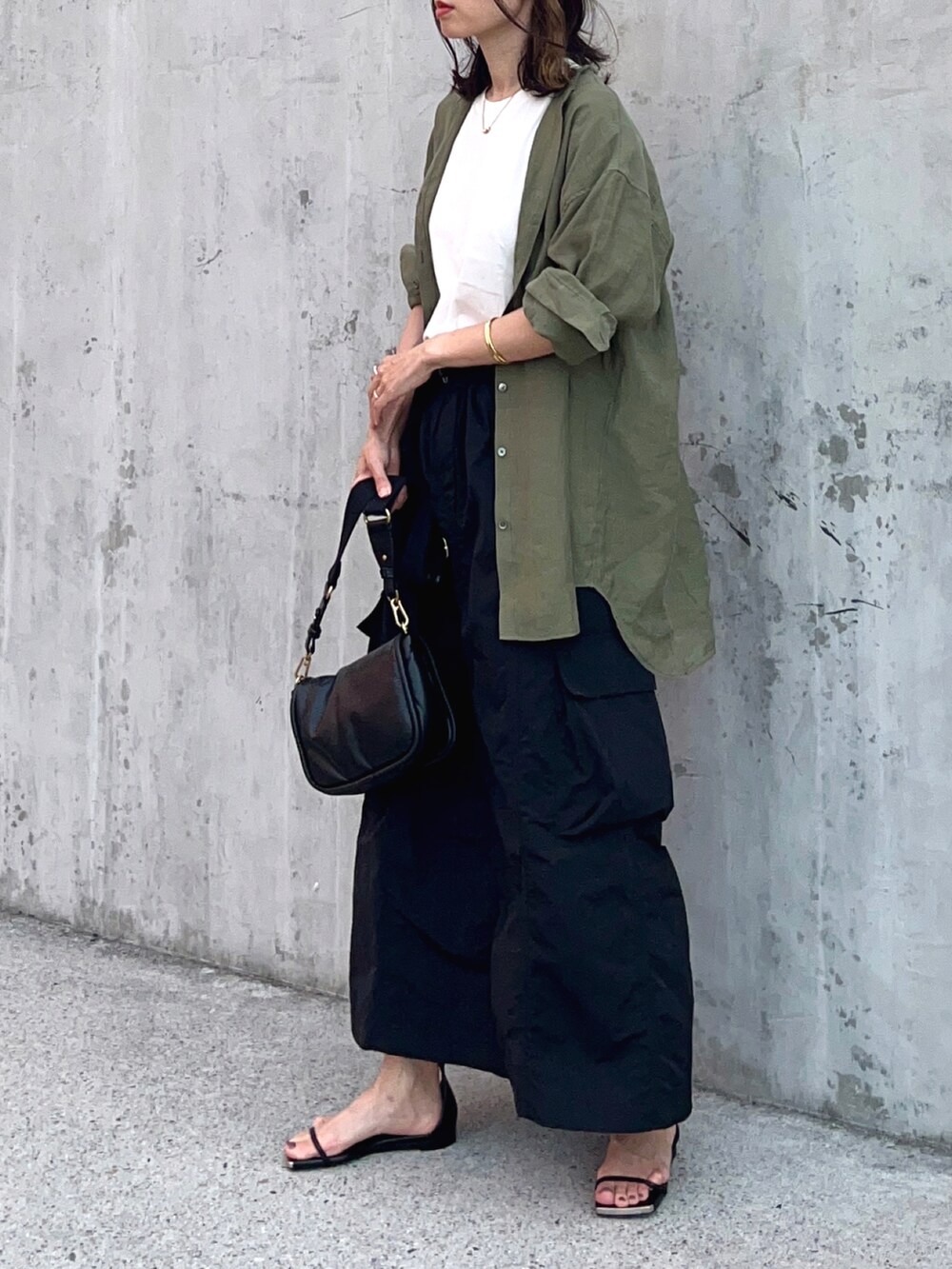 ホワイト系のTシャツ/カットソー、ブラック系のスカート、ブラック系のサンダルを着用したレディースの夏コーディネートの2枚目の写真