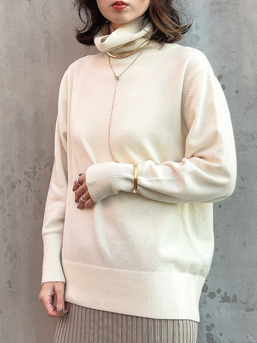 ホワイト系のニット/セーター、イエロー系のシャツ/ブラウス、ベージュ系のスカートを着用したレディースの冬コーディネートの3枚目の写真