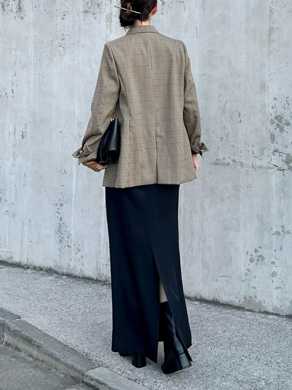 ブラウン系のニット/セーター、ベージュ系のテーラードジャケット、ブラック系のスカートを着用したレディースの冬コーディネートの3枚目の写真