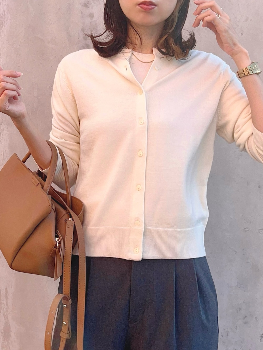 ホワイト系のニット/セーター、ホワイト系のカーディガン/ボレロ、グレー系のパンツを着用したレディースの秋コーディネートの3枚目の写真