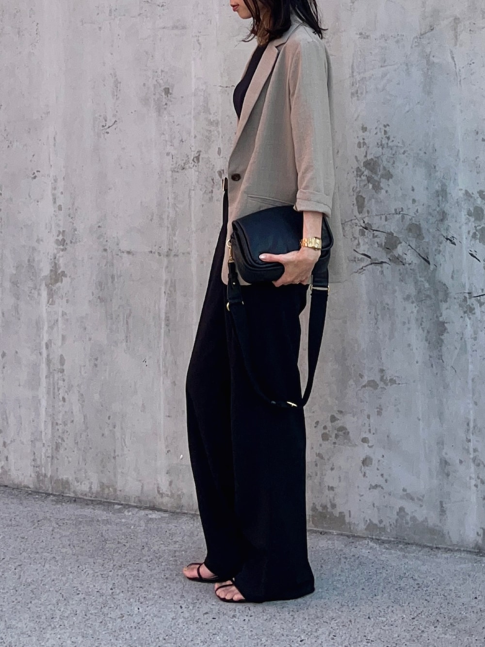 ブラック系のタンクトップ、グリーン系のテーラードジャケット、ブラック系のパンツを着用したレディースの春コーディネートの3枚目の写真