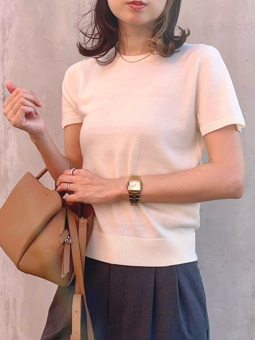 ホワイト系のニット/セーター、ホワイト系のカーディガン/ボレロ、グレー系のパンツを着用したレディースの秋コーディネートの2枚目の写真