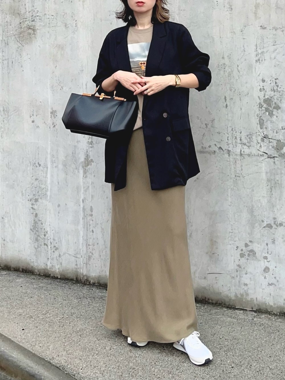 ベージュ系のTシャツ/カットソー、グリーン系のスカート、シルバー系のスニーカーを着用したレディースの冬コーディネートの3枚目の写真