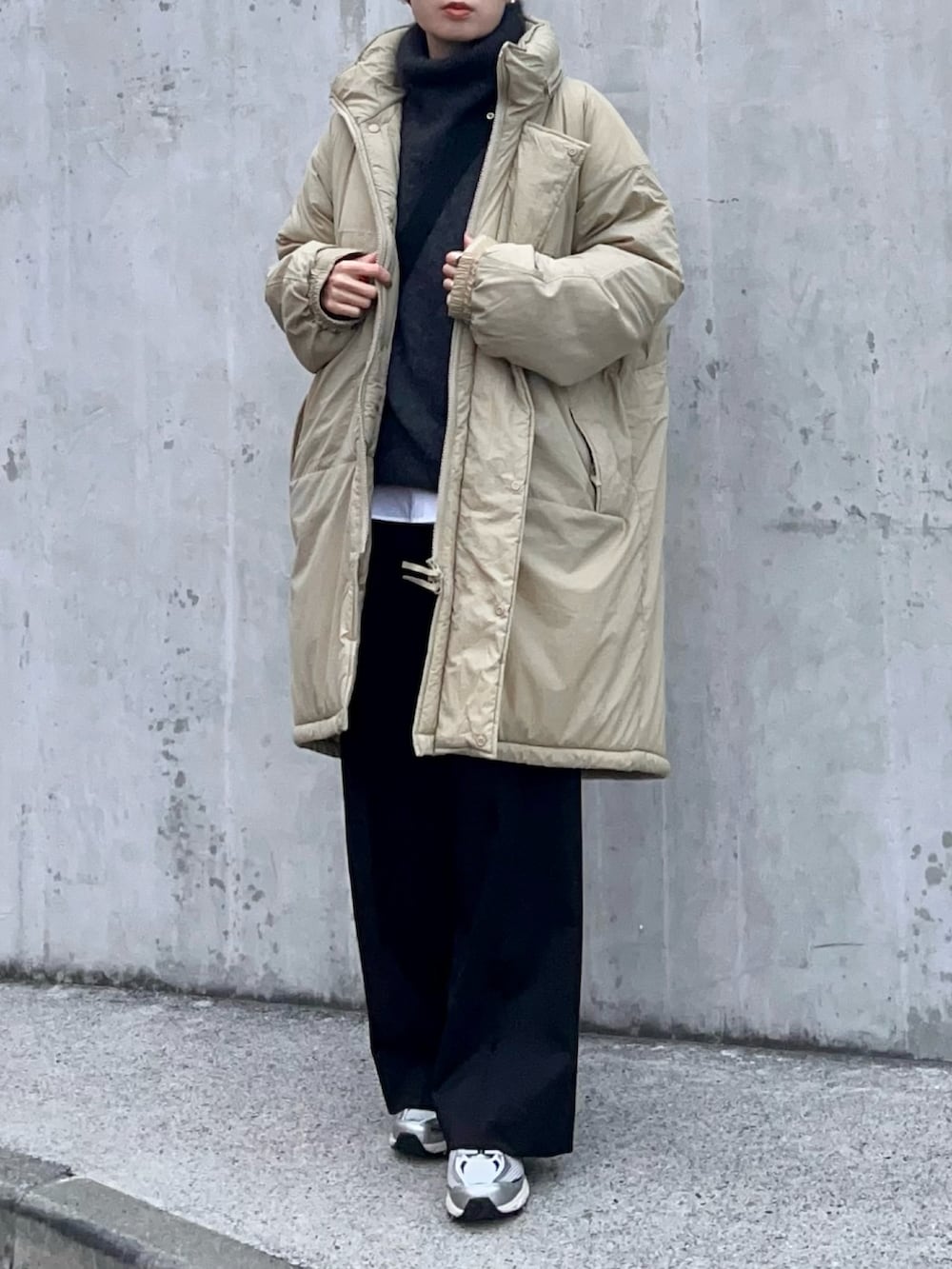 グレー系のニット/セーター、ホワイト系のシャツ/ブラウス、ブラック系のスラックスを着用したレディースの冬コーディネートの2枚目の写真