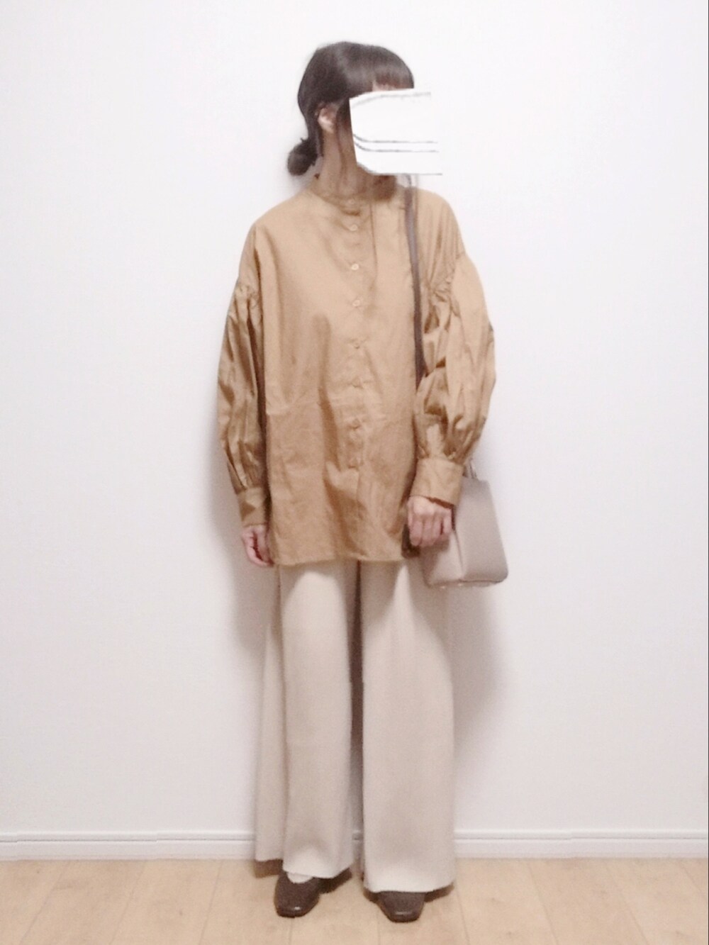 オレンジ系のシャツ/ブラウス、ベージュ系のショルダーバッグ、ブラウン系のパンプスを着用したレディースの秋コーディネートの2枚目の写真