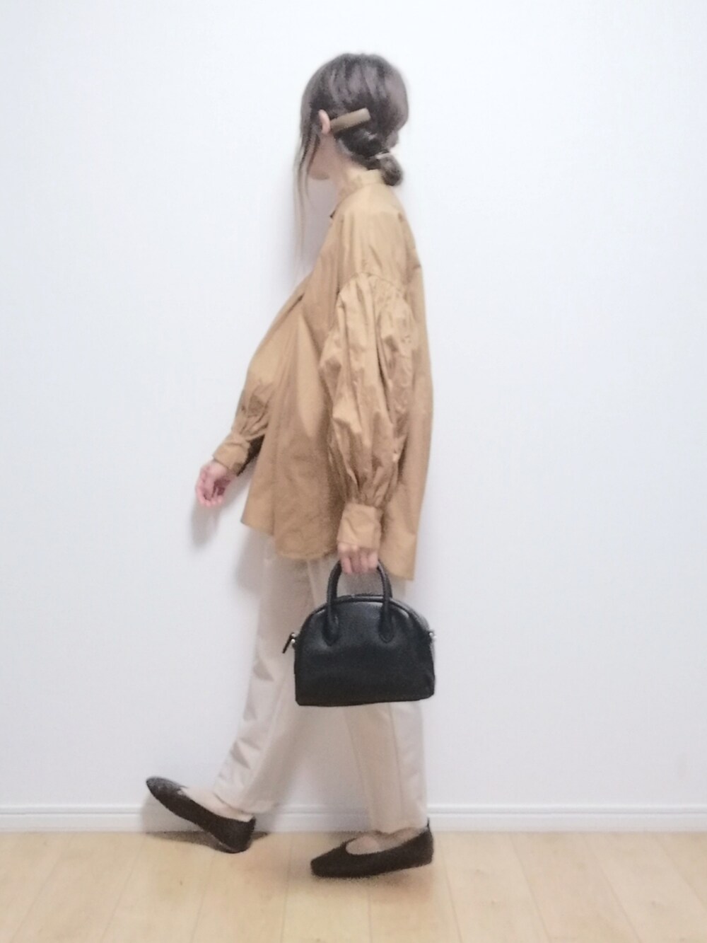 ブラック系のボストンバッグ、オレンジ系のシャツ/ブラウス、ベージュ系のその他パンツを着用したレディースの春コーディネートの2枚目の写真