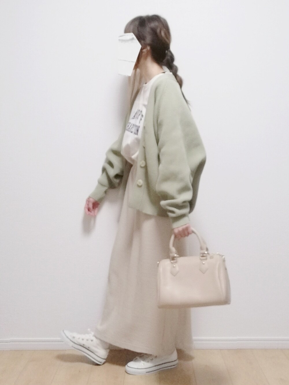 ベージュ系のボストンバッグ、ベージュ系のスカート、ホワイト系のスニーカーを着用したレディースの春コーディネートの2枚目の写真
