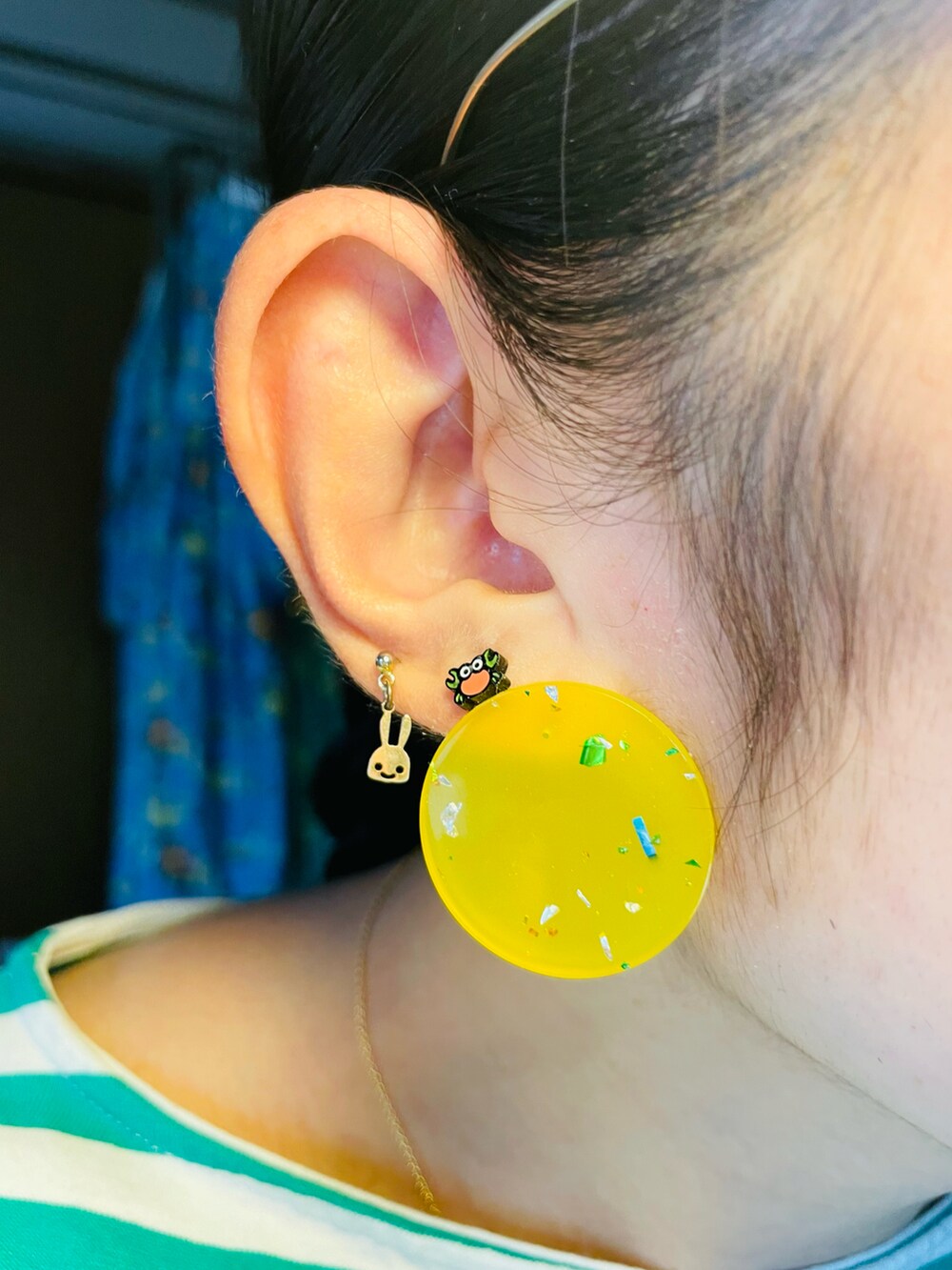 オレンジ系のスカート、グレー系のブーツ、グリーン系のTシャツ/カットソーを着用したレディースの夏コーディネートの2枚目の写真