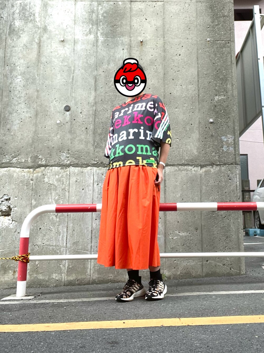 オレンジ系のスカート、ピンク系のスニーカー、その他のTシャツ/カットソーを着用したレディースの春コーディネートの2枚目の写真