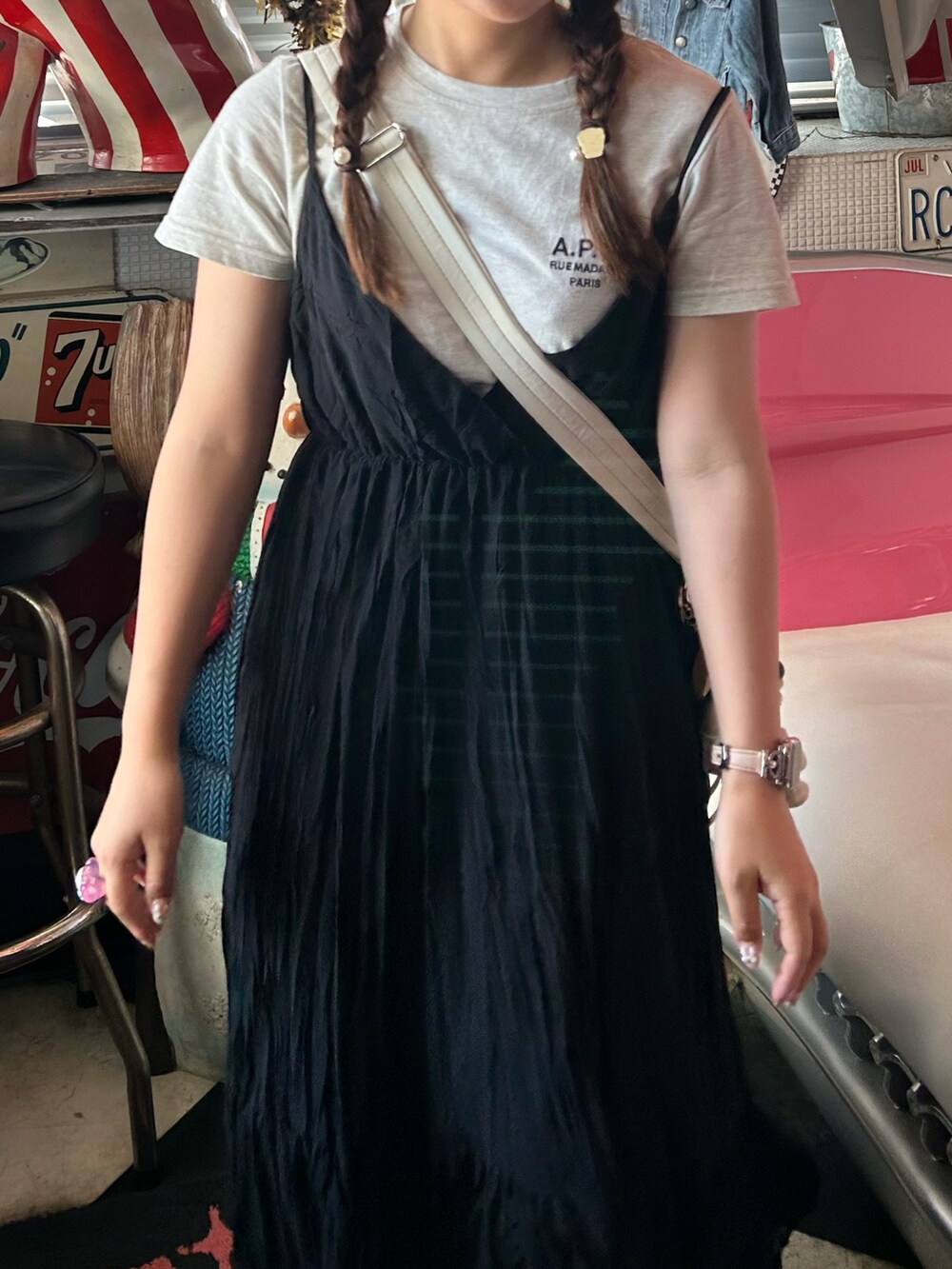 ブラック系のワンピース、ブラック系のスニーカー、ホワイト系のショルダーバッグを着用したレディースの夏コーディネートの2枚目の写真