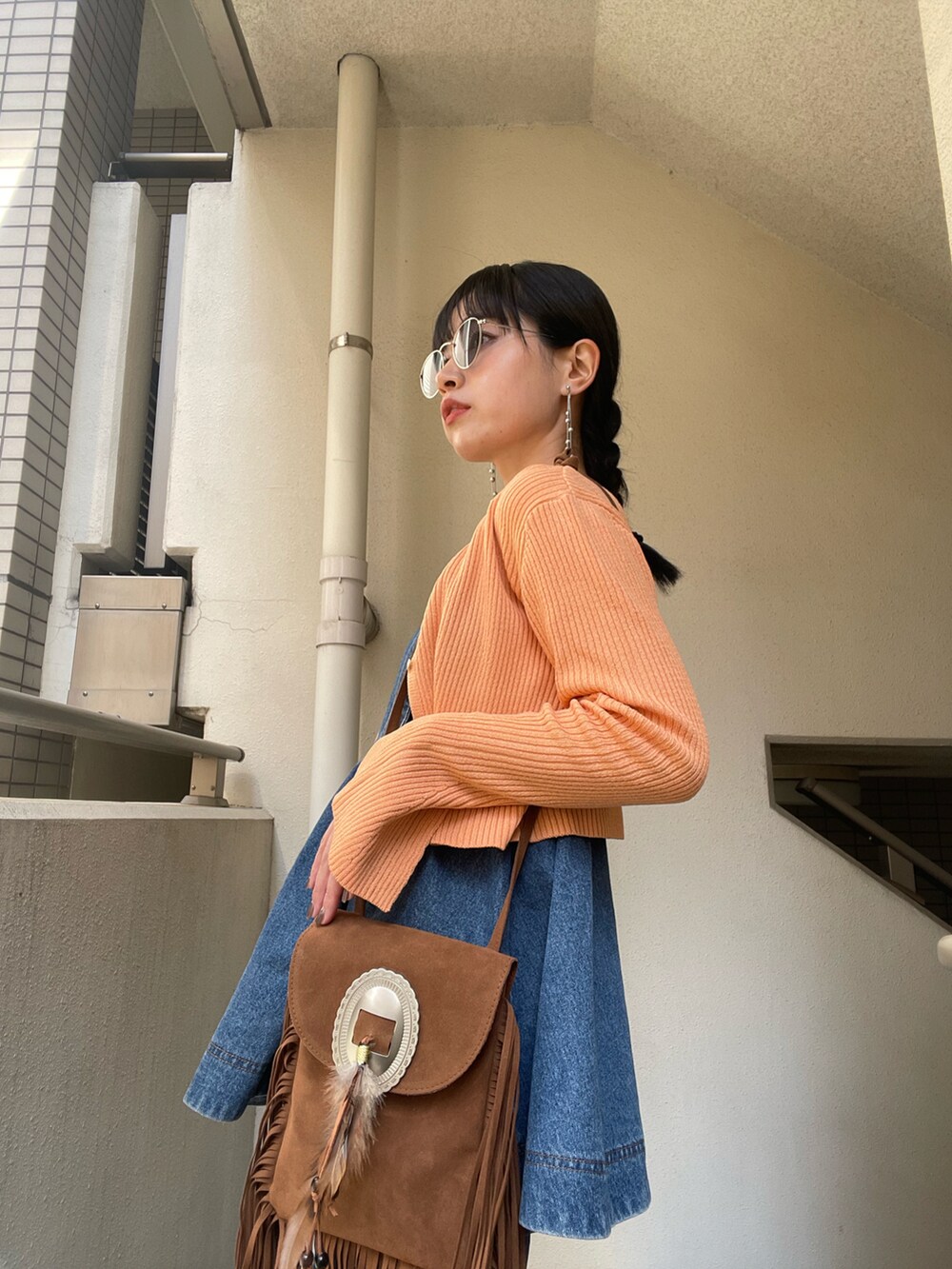 ブルー系のオールインワン・サロペット、オレンジ系のカーディガン/ボレロを着用したレディースの春コーディネートの2枚目の写真