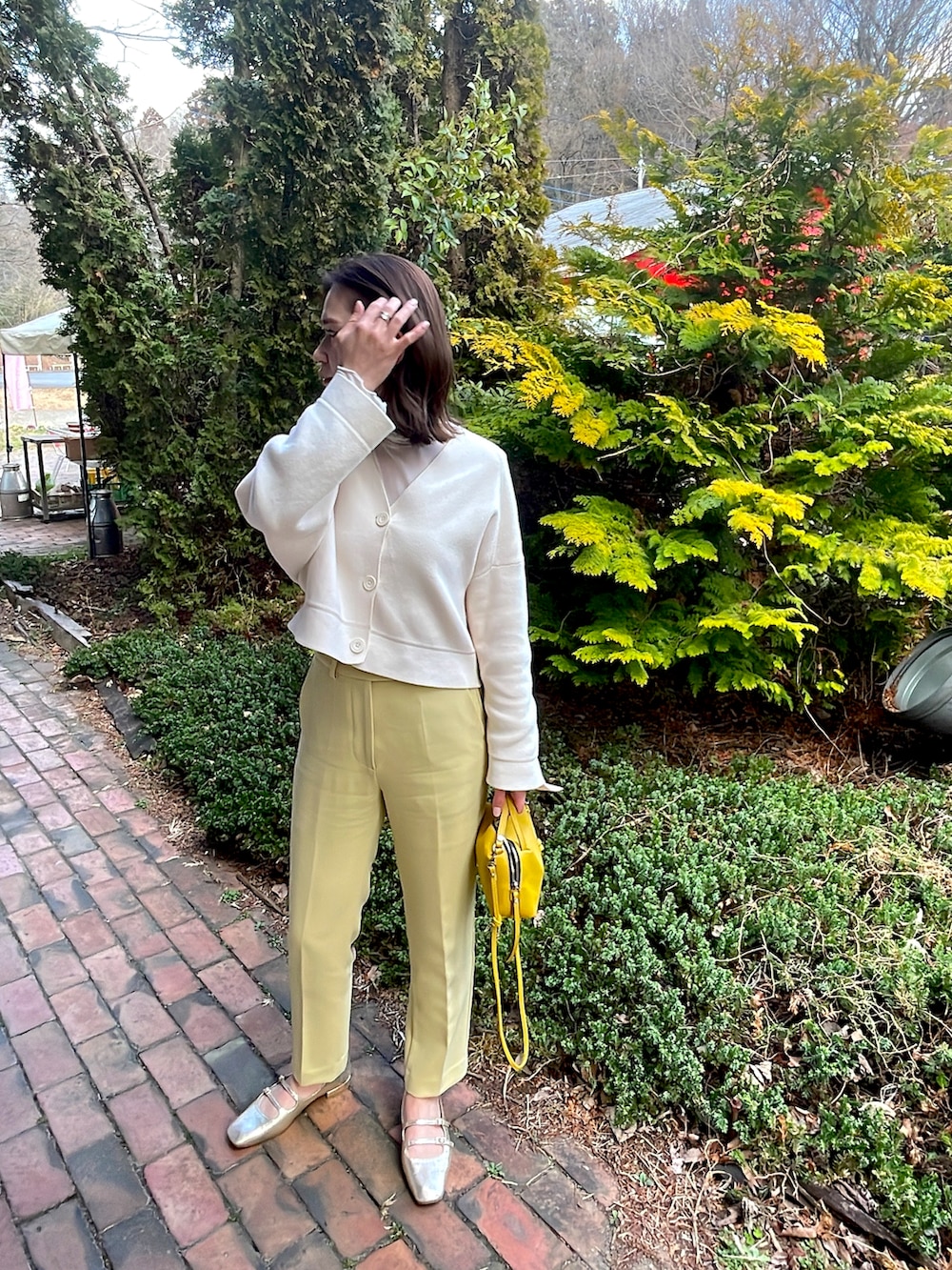 ホワイト系のカーディガン/ボレロ、イエロー系のその他パンツ、ゴールド系のその他シューズを着用したレディースの春コーディネートの2枚目の写真