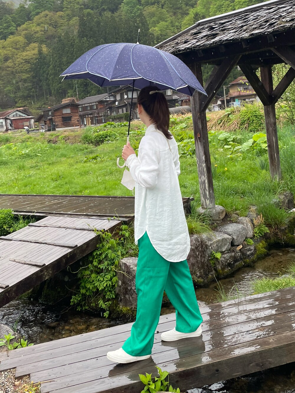 グリーン系のスラックス、ホワイト系のシャツ/ブラウス、ホワイト系のスニーカーを着用したレディースの春コーディネートの2枚目の写真