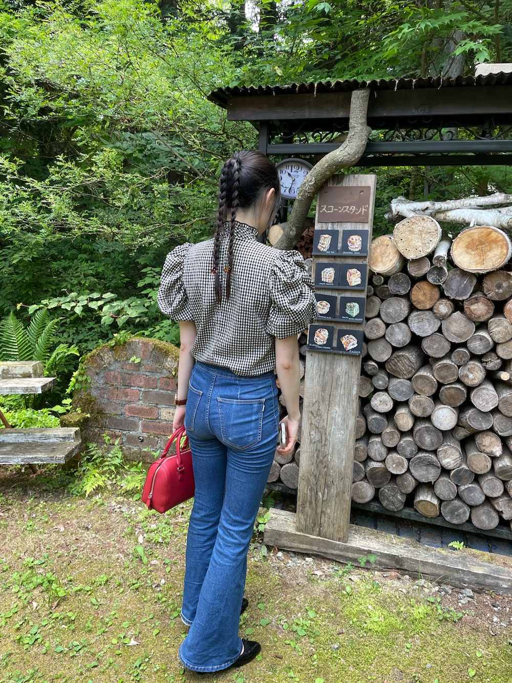 ブラック系のシャツ/ブラウス、グリーン系のバッグ、ブラック系のパンプスを着用したレディースの夏コーディネートの3枚目の写真