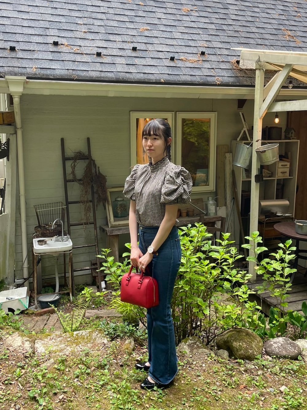 ブラック系のシャツ/ブラウス、グリーン系のバッグ、ブラック系のパンプスを着用したレディースの夏コーディネートの2枚目の写真