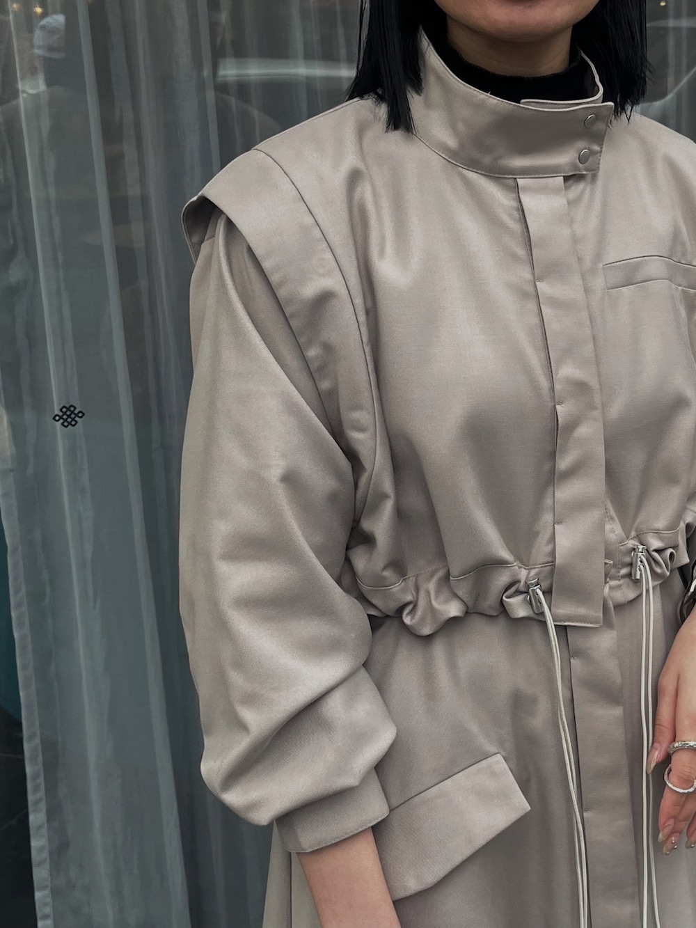 ベージュ系のモッズコートを着用したレディースの春コーディネートの2枚目の写真